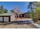 The front exterior features a two-car garage and a quaint covered porch with a wooden door at 11540 Inspiration Rd, Golden, CO 80403