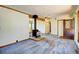 Spacious living room featuring a wood burning stove, ceiling fan, and exterior access at 11540 Inspiration Rd, Golden, CO 80403