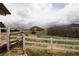 Exterior view of barns surrounded by a white fence and scenic landscapes, showcasing rural charm at 3530 Doolittle Rd, Monument, CO 80132
