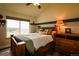Cozy bedroom featuring a wooden bed frame and dresser, complemented by a large window with scenic views at 3530 Doolittle Rd, Monument, CO 80132
