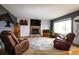 Cozy living room with a fireplace, large windows, and comfortable seating at 3530 Doolittle Rd, Monument, CO 80132