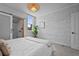 Bright bedroom boasts painted brick wall and a barn door to the ensuite bathroom at 3003 California St, Denver, CO 80205