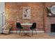 Charming dining area featuring exposed brick wall and a decorative fireplace at 3003 California St, Denver, CO 80205