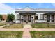 Charming townhome featuring brick facade, inviting front porch, and well-manicured lawn at 3003 California St, Denver, CO 80205