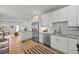 Modern kitchen with white cabinets, stainless steel appliances, and a view to the living area at 3003 California St, Denver, CO 80205