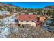 Two-story home with deck and greenhouse, surrounded by snowy trees at 347 Buena Vista, Palmer Lake, CO 80133