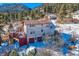 Aerial view of two-story home with deck, nestled in snowy mountain community at 347 Buena Vista, Palmer Lake, CO 80133