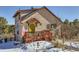 Charming stucco home with unique details, a red deck, and snowy landscape at 347 Buena Vista, Palmer Lake, CO 80133