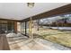 Covered patio area with tiled flooring, leading to a spacious backyard with a wood fence at 3680 S Pontiac Way, Denver, CO 80237