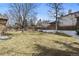 Large backyard with a well-maintained lawn, mature trees, and a wooden fence at 3680 S Pontiac Way, Denver, CO 80237