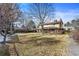 Expansive backyard featuring a lush lawn, mature trees, and a charming two-story home with brick accents at 3680 S Pontiac Way, Denver, CO 80237