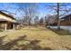 Spacious backyard with a lush green lawn, mature trees, and a full wooden fence at 3680 S Pontiac Way, Denver, CO 80237