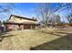 Extensive backyard view, showcasing a well-kept lawn, mature trees, a full wooden fence, and a charming home exterior at 3680 S Pontiac Way, Denver, CO 80237