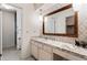 Well-lit bathroom with a marble countertop, patterned wallpaper, and a large, ornate mirror at 3680 S Pontiac Way, Denver, CO 80237