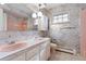 Retro bathroom with dual pink sinks, floral wallpaper, and vintage fixtures at 3680 S Pontiac Way, Denver, CO 80237