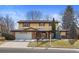 Two-story home with a blend of yellow siding and brick, complemented by a well-maintained front lawn and mature trees at 3680 S Pontiac Way, Denver, CO 80237