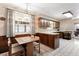 Traditional kitchen featuring wooden cabinets, tiled flooring, and an adjacent dining area at 3680 S Pontiac Way, Denver, CO 80237