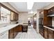 Kitchen with wooden cabinets and a tiled floor; view into the adjacent dining area at 3680 S Pontiac Way, Denver, CO 80237