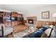 Living room with a brick fireplace, built-in shelving, hardwood floors and comfortable seating at 3680 S Pontiac Way, Denver, CO 80237