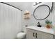 Modern bathroom featuring a round mirror, updated vanity, and stylish shower curtain at 9255 E Lehigh Ave # 208, Denver, CO 80237
