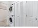 A laundry room features stacked washer and dryer, with storage space and a neutral color palette at 9255 E Lehigh Ave # 208, Denver, CO 80237