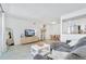 Bright living room featuring neutral decor, a comfortable grey couch, and an adjacent dining area at 9255 E Lehigh Ave # 208, Denver, CO 80237