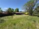 Large backyard featuring an overgrown lawn, a wood fence, and a patio, providing ample outdoor space at 8491 W Star Cir, Littleton, CO 80128