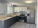 Updated kitchen with stainless steel appliances, light countertops, dark cabinets, and hardwood floors at 8491 W Star Cir, Littleton, CO 80128