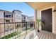 View of a condo balcony featuring wood floors and black metal railing that overlooks a lush green lawn at 15345 W 64Th Ln # 201, Arvada, CO 80007