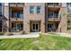 Exterior of a condo building with green grass, brick facade and inviting entrance at 15345 W 64Th Ln # 201, Arvada, CO 80007