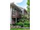 Attractive home featuring a cozy porch, brick accents, and lush landscaping with colorful flowers at 1470 S Quebec Way # 245, Denver, CO 80231