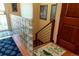 Well-lit hallway with glass block partition, hardwood floors, a patterned rug, and a staircase at 1470 S Quebec Way # 245, Denver, CO 80231