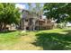 Spacious backyard showcasing a large deck, lush green lawn, mature trees, and landscaping at 1123 Oakhurst Dr, Broomfield, CO 80020