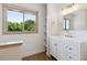 Bright bathroom with a single sink vanity, open shelving, and a large window at 1123 Oakhurst Dr, Broomfield, CO 80020