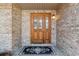 Elegant front door with glass panes and decorative details, complemented by brick siding and a welcoming mat at 1123 Oakhurst Dr, Broomfield, CO 80020