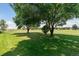 Picturesque view of a lush green golf course with mature trees casting shadows on the manicured lawn at 1123 Oakhurst Dr, Broomfield, CO 80020