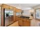 Spacious kitchen with island cooktop and stainless steel refrigerator at 1123 Oakhurst Dr, Broomfield, CO 80020