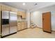 Functional kitchenette features stainless steel refrigerator, ample cabinets, and tiled floor and backsplash at 1123 Oakhurst Dr, Broomfield, CO 80020