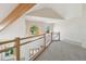 Bright open loft with wood and glass railings overlooking the lower level of the home at 1123 Oakhurst Dr, Broomfield, CO 80020