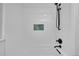 Sleek tub/shower features modern black fixtures, a built-in shelf, and bright white tiling at 5730 E 19Th Ave, Denver, CO 80220