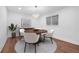 A cozy dining room featuring a round wood table, modern white chairs, and stylish lighting at 5730 E 19Th Ave, Denver, CO 80220