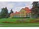 Long front lawn with green and colorful flower beds, and large building at 5730 E 19Th Ave, Denver, CO 80220