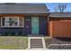 Inviting entrance with a teal front door, stone steps, and manicured landscaping at 5730 E 19Th Ave, Denver, CO 80220