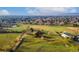 Expansive property showcases lush green land, mature trees, and a residence with additional outbuildings; clear blue skies overhead at 5800 W Bowles Ave, Littleton, CO 80123
