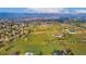 Scenic aerial view highlights rolling green fields, with homes, schools and community buildings visible in the distance at 5800 W Bowles Ave, Littleton, CO 80123