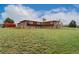 Expansive backyard view of brick and wood home, offering privacy and space for outdoor enjoyment at 5800 W Bowles Ave, Littleton, CO 80123