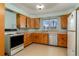 Classic kitchen features wood cabinets, stainless steel dishwasher, and bright natural light at 5800 W Bowles Ave, Littleton, CO 80123