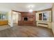 Living room featuring a unique brick fireplace, hardwood floors, and abundant light at 5800 W Bowles Ave, Littleton, CO 80123