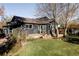 Exterior rear view of a dark gray home with a lush lawn, patio, and mature trees at 4269 Carter Trl, Boulder, CO 80301