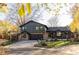 Two-story house with dark siding, stone accents, a well-manicured lawn, mature trees, and a paved driveway at 4269 Carter Trl, Boulder, CO 80301